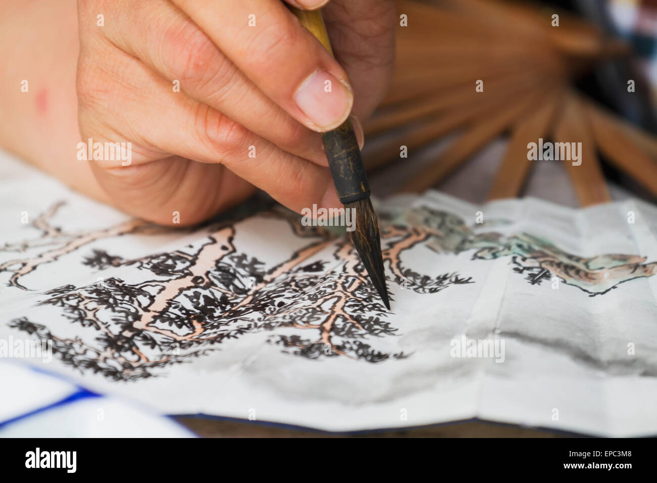 Künstler malen einen Fan mit einem traditionellen chinesischen Pinsel, Xidi, Anhui, China Stockfoto