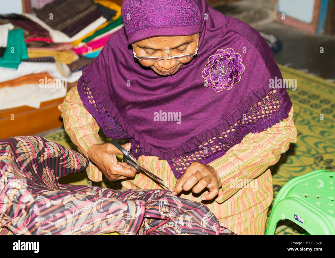 Frau ausbessern eine Kleidungsstück bei einem Lurik Workshop in Cawas Dorf, Klaten, Java, Indonesien Stockfoto