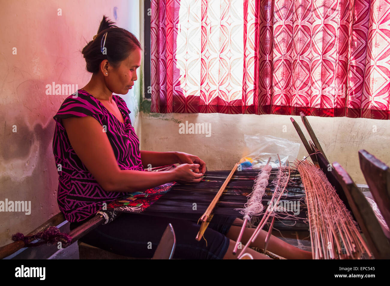 Weaver, die mit einem Backstrap Loom um zu produzieren ein Songket ergänzende Schuß gemusterte Textilien, Sidemen, Bali, Indonesien Stockfoto