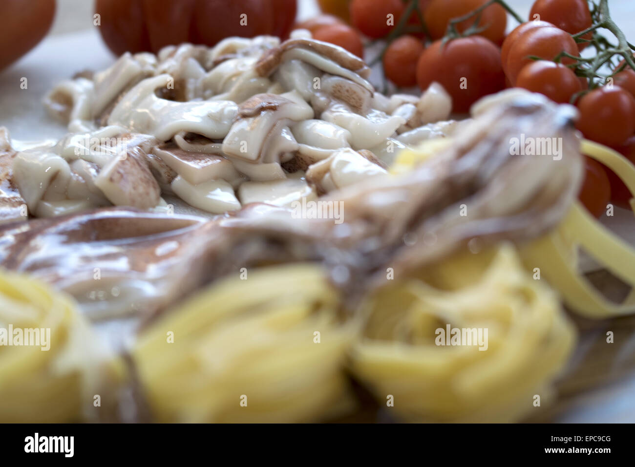Gericht des Meeres mit Tagliatelle mit Tintenfisch und frischen Tomaten Stockfoto