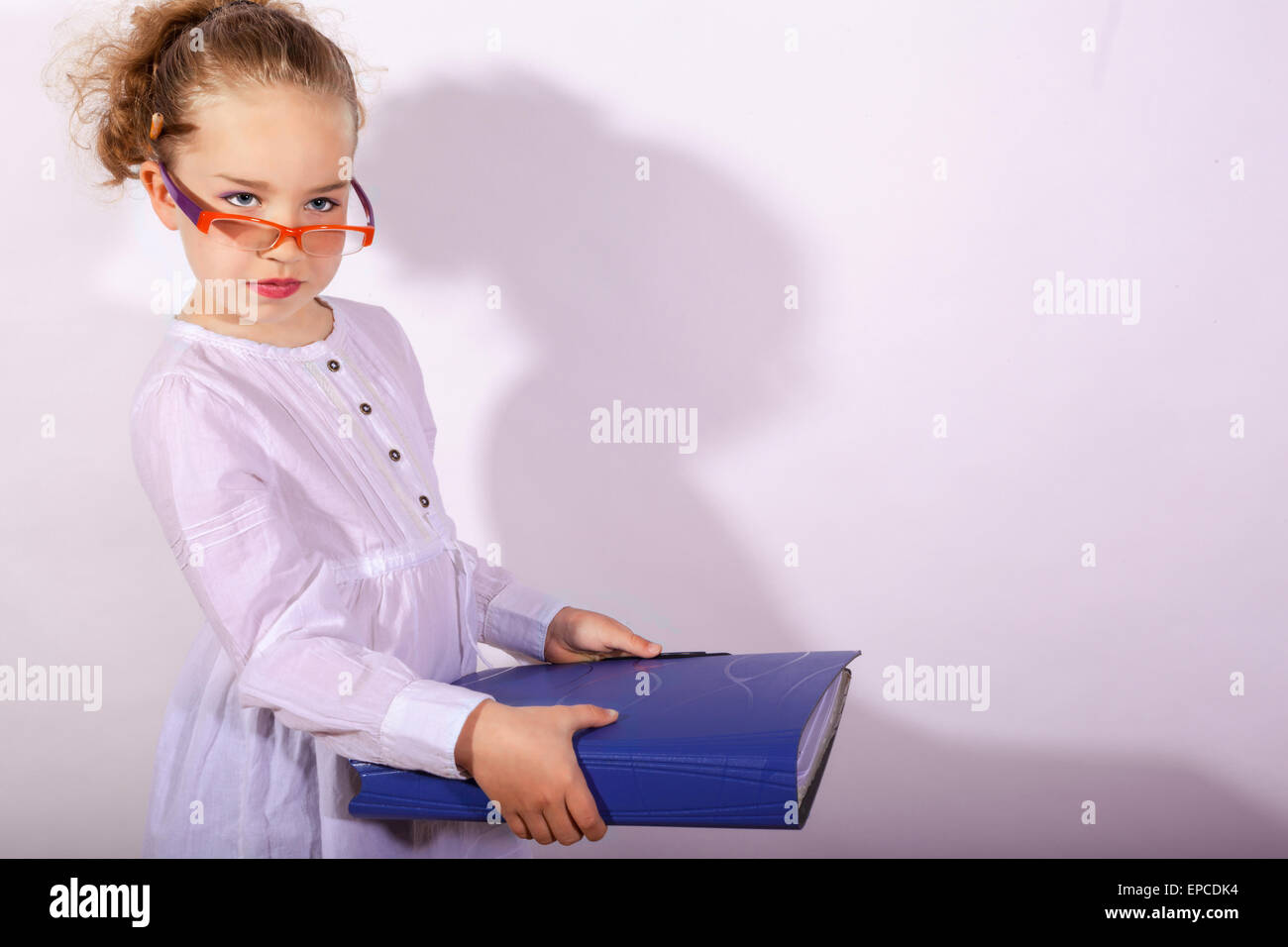 Grundlegende Schulkind mit Akte in der Hand und Bleistift hinter dem Ohr Stockfoto