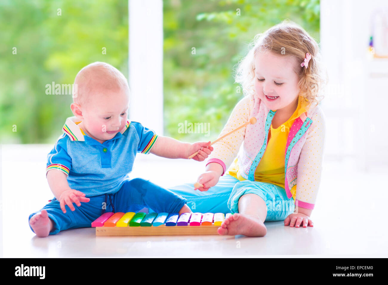 Zwei kleine Kinder - niedliche lockige Kleinkind Mädchen und eine lustige Baby Boy, Bruder und Schwester musizieren, Spaß mit Xylophon Stockfoto