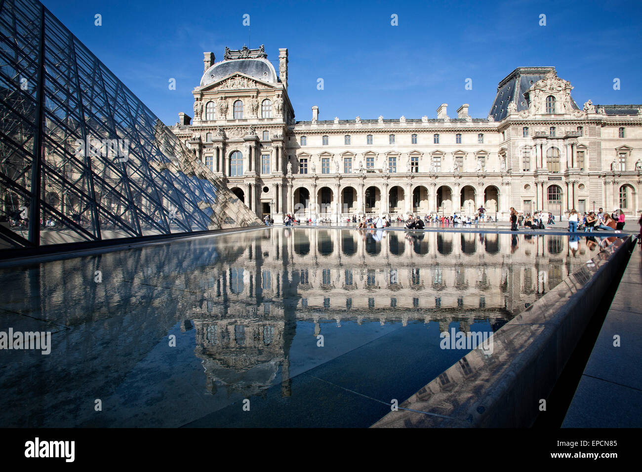 Touristen versammeln sich in der Nähe einer reflektierenden Pool im Innenhof des Louvre.  Paris, Frankreich. Stockfoto
