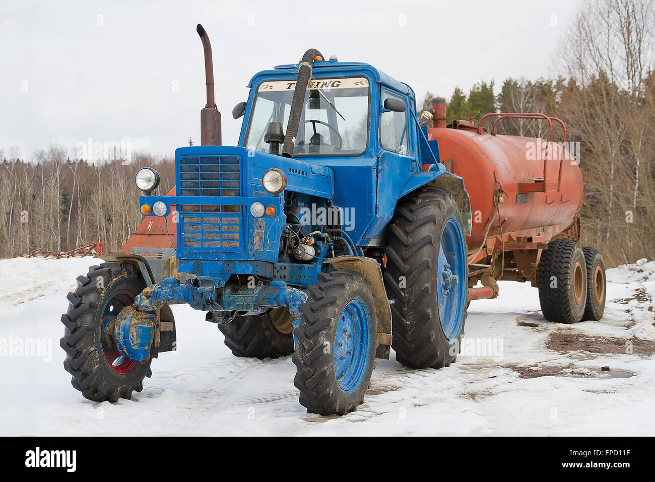 Alten Bauernhof Traktor mit Anhänger im winter Stockfoto