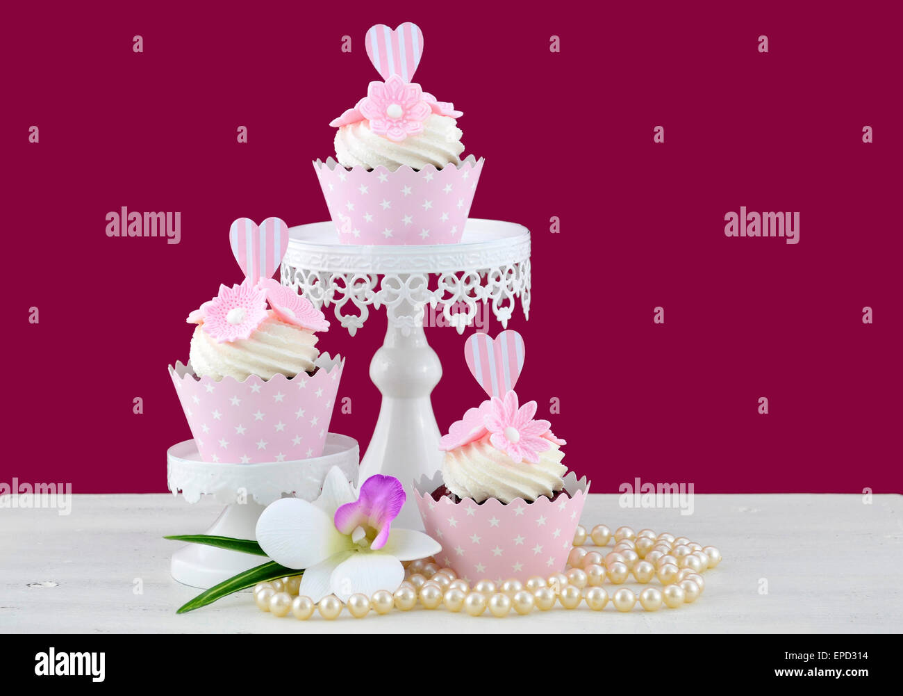 Hochzeit-June Bride Konzept mit Muffins und Perlen zu weißen shabby chic Tisch und Marsala Farbe Hintergrund. Stockfoto