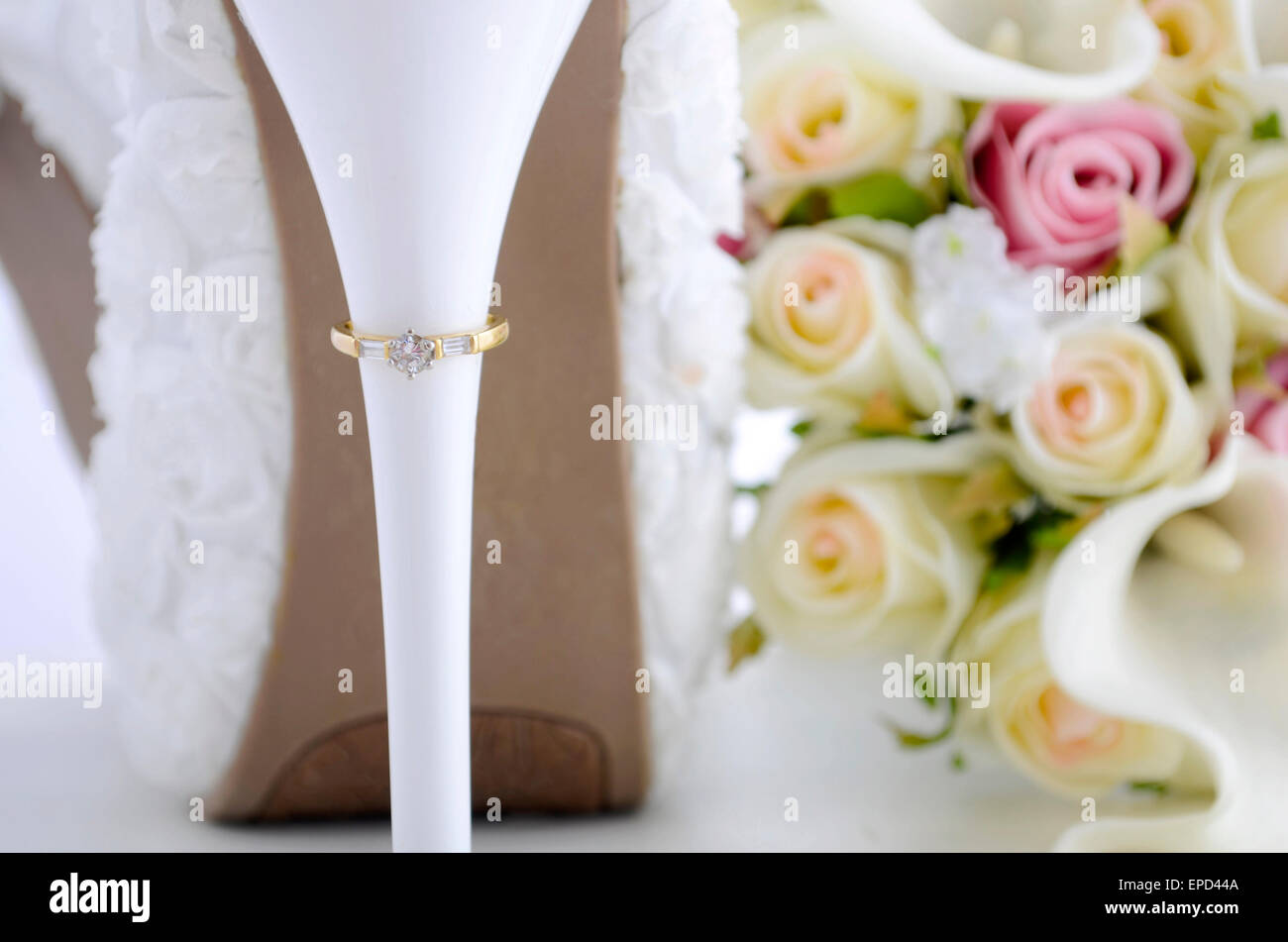 Hochzeit Tag Konzept mit Ringen an der Ferse des schönen weißen Blumen Braut Stöckelschuhen mit Bouquet auf weißen shabby chic Holz ta Stockfoto