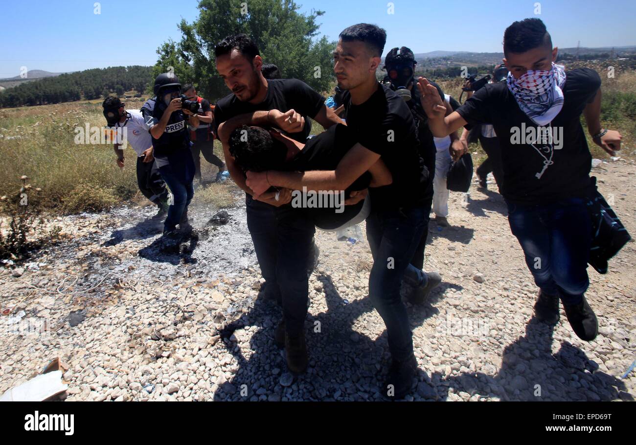 Nablus. 16. Mai 2015. Einen verletzten palästinensischen Demonstrant wird weggetragen, nachdem er mit einer Kautschuk-Kugel abgefeuert durch israelische Militär während der Auseinandersetzungen nach einem Protest Kennzeichnung Nakba Day in der Nähe von Israels Howrah Kontrollpunkt in der Nähe von West Bank Stadt von Nablus, 16. Mai 2015 getroffen wurde. Die Nakba, was bedeutet "Tag der Katastrophe", ist der palästinensischen Tag zum Gedenken an die Vertreibung, die den arabisch-israelischen Krieg 1948 folgten. © Ayman Nobani/Xinhua/Alamy Live-Nachrichten Stockfoto