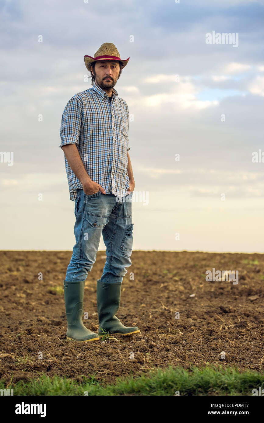 Porträt von erwachsenen männlichen Bauern stehen auf fruchtbares Agrarland Bauernhof Boden, Blick in die Kamera Stockfoto