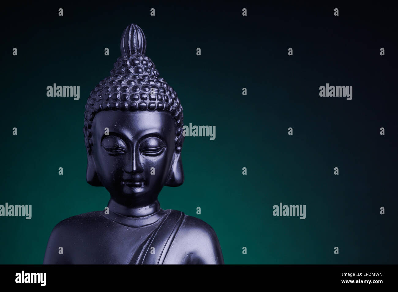 Statue von Buddha mit grüner Hintergrundbeleuchtung Stockfoto