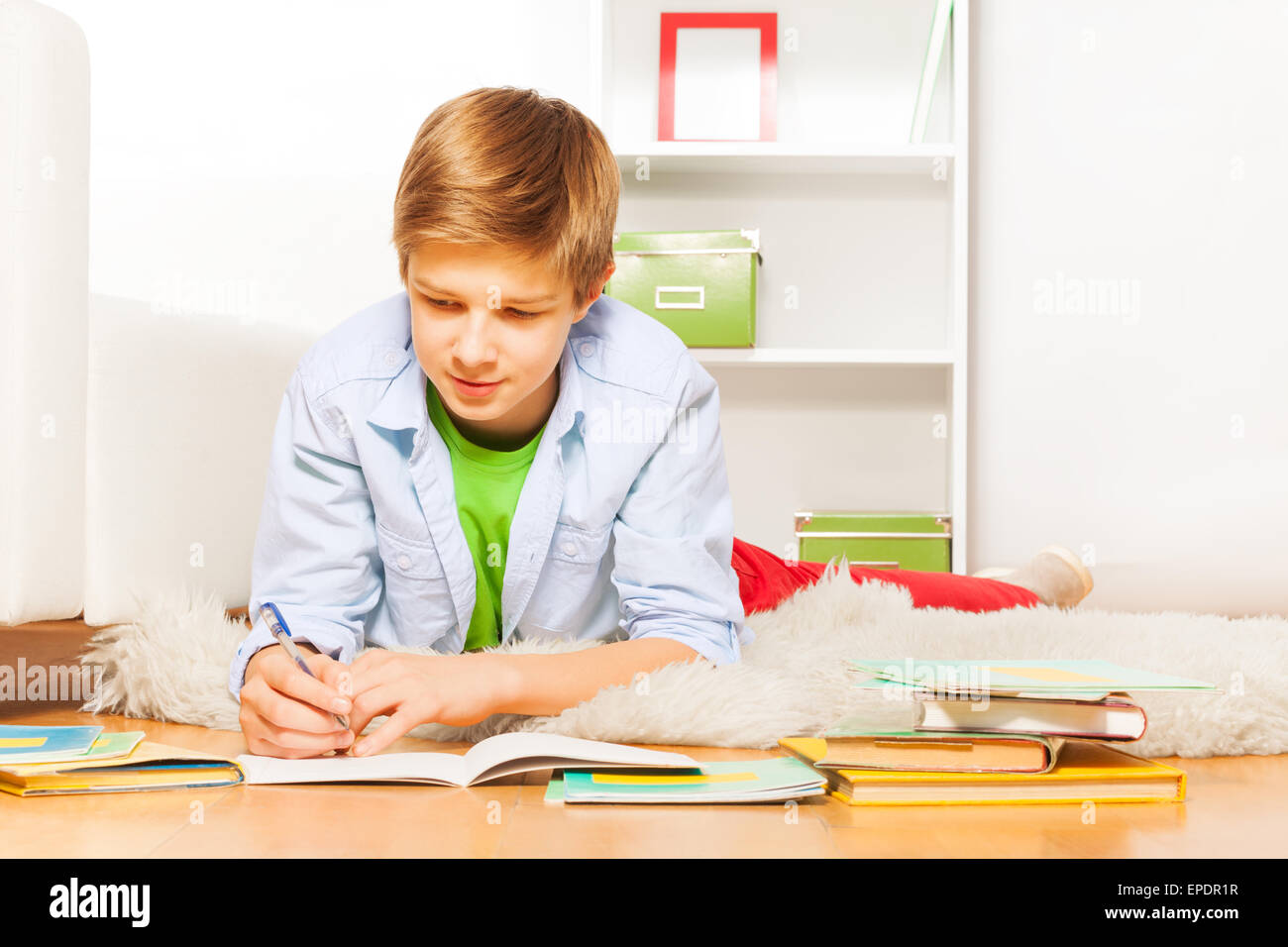 Smart Boy Hausaufgaben auf dem Boden zu Hause Stockfoto