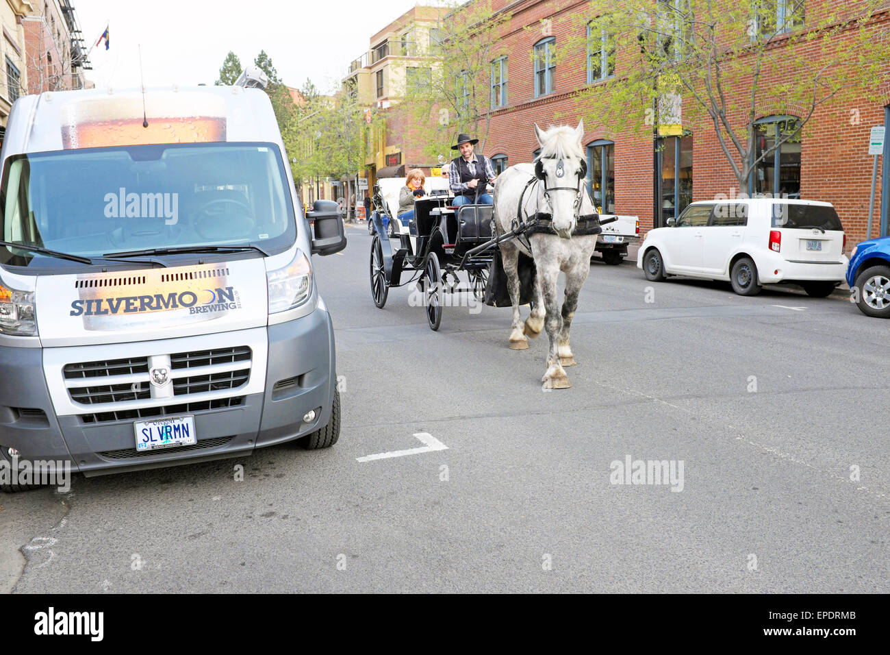 Touristen machen einen Abend Fahrt mit der Kutsche in der Innenstadt von Bend, Oregon, im Frühjahr. Stockfoto