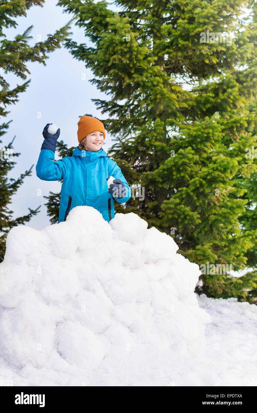 Junge im blauen Winterjacke Schneeballschlachten Stockfoto