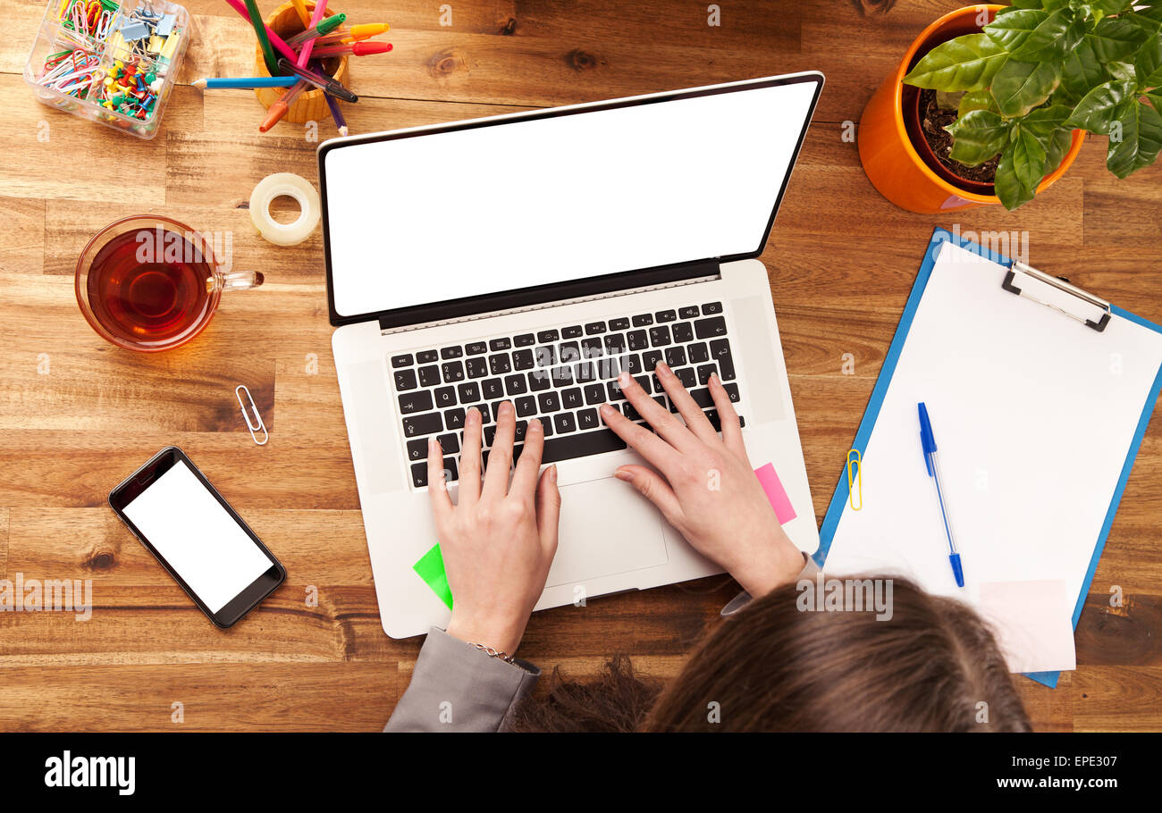 Junge Frau mit Laptop am Schreibtisch aus Holz mit leeren Bildschirm für Text platziert. Schuss aus Vogelperspektive Stockfoto