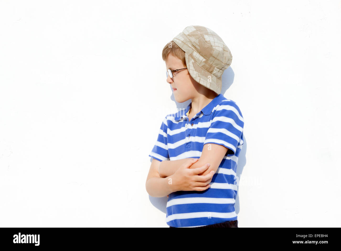 der kleine Junge ein Tyrann in Gläsern und einer Kappe posiert im freien Stockfoto