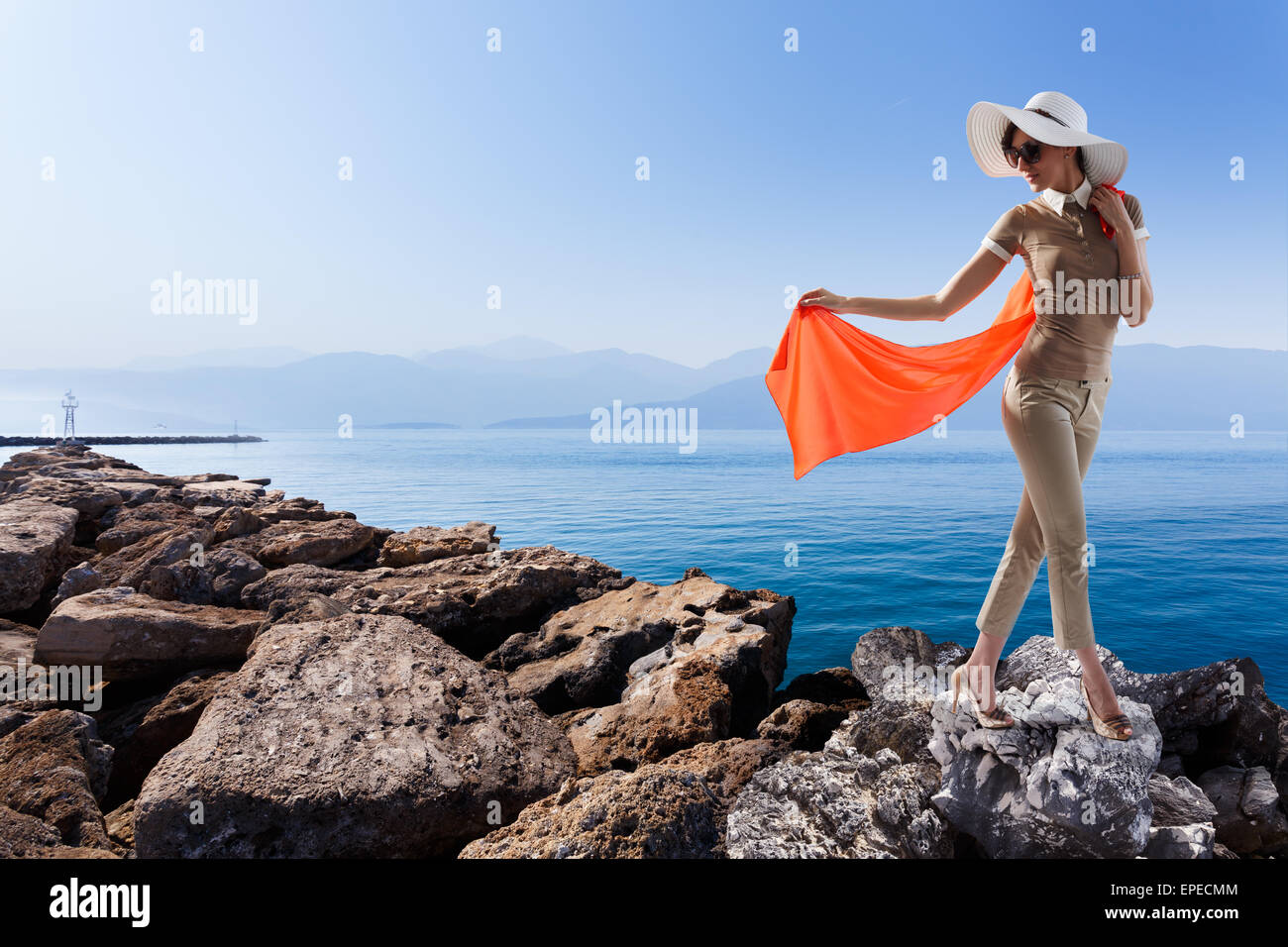 Stilvolle Frau stehend auf der Pierce gegen wunderschöne Seenlandschaft halten Sie ihre roten Streaming-Schal. Urlaub, Reisekonzept Stockfoto