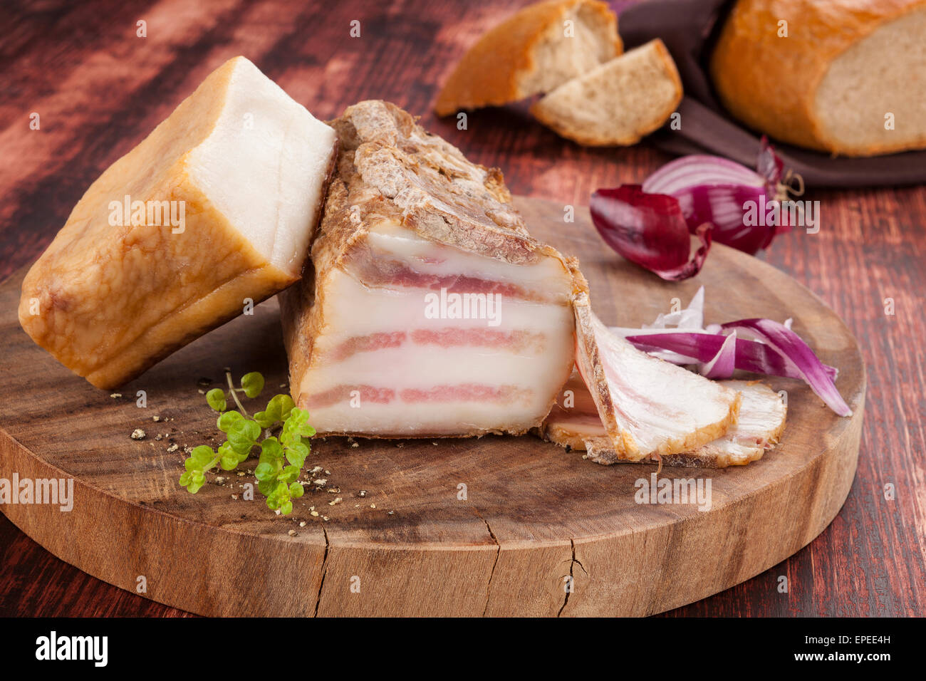 Köstlichen Speck Hintergrund, Vintage Landhausstil. Speck auf Schneidbrett aus Holz. Kulinarischen Fleisch zu essen. Stockfoto