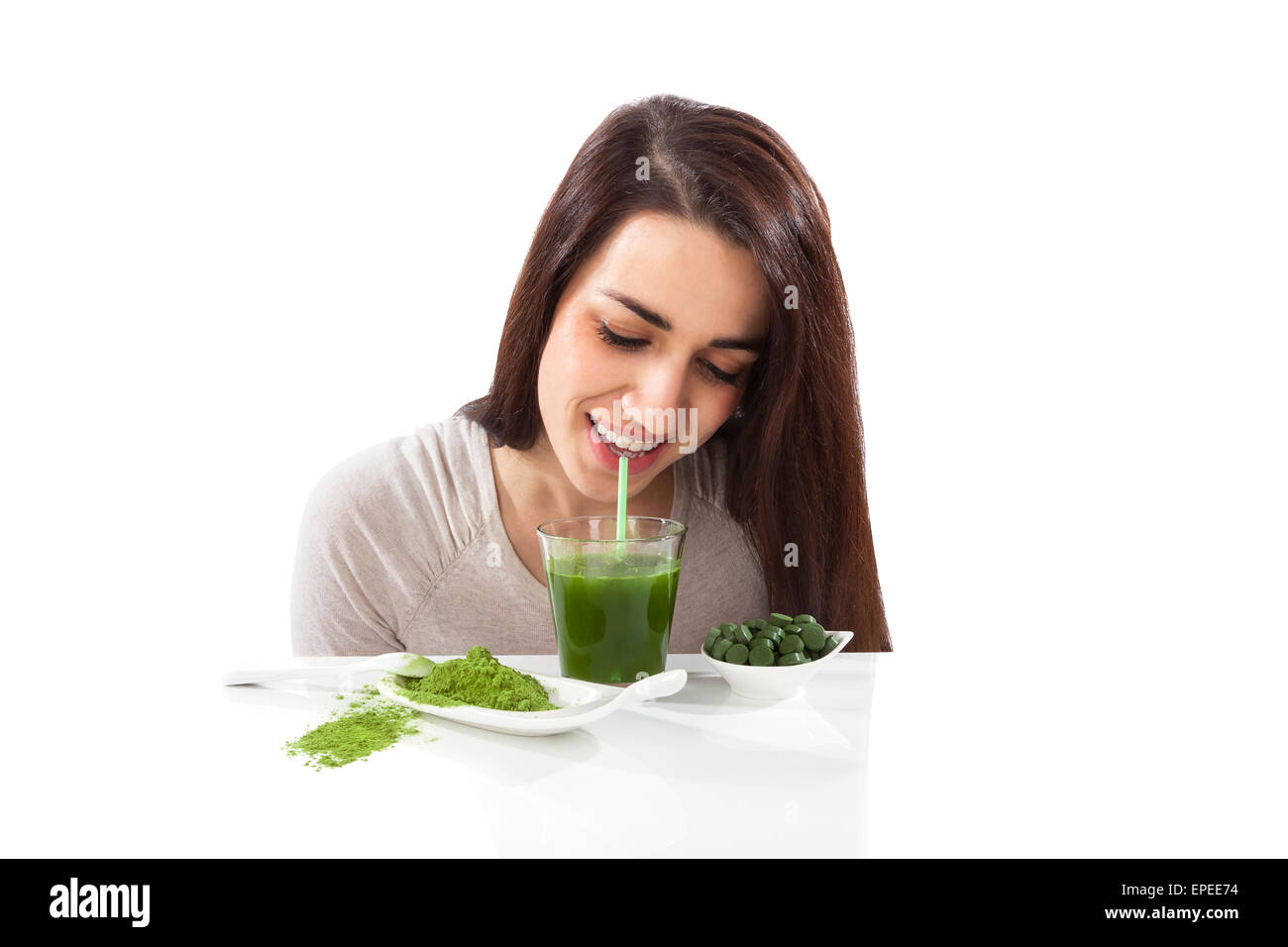 Schönes lächelndes Mädchen grüne Getränk trinken. Spirulina, Chlorella und Weizengras. Gesunde Lebensweise, Entgiftung. Stockfoto