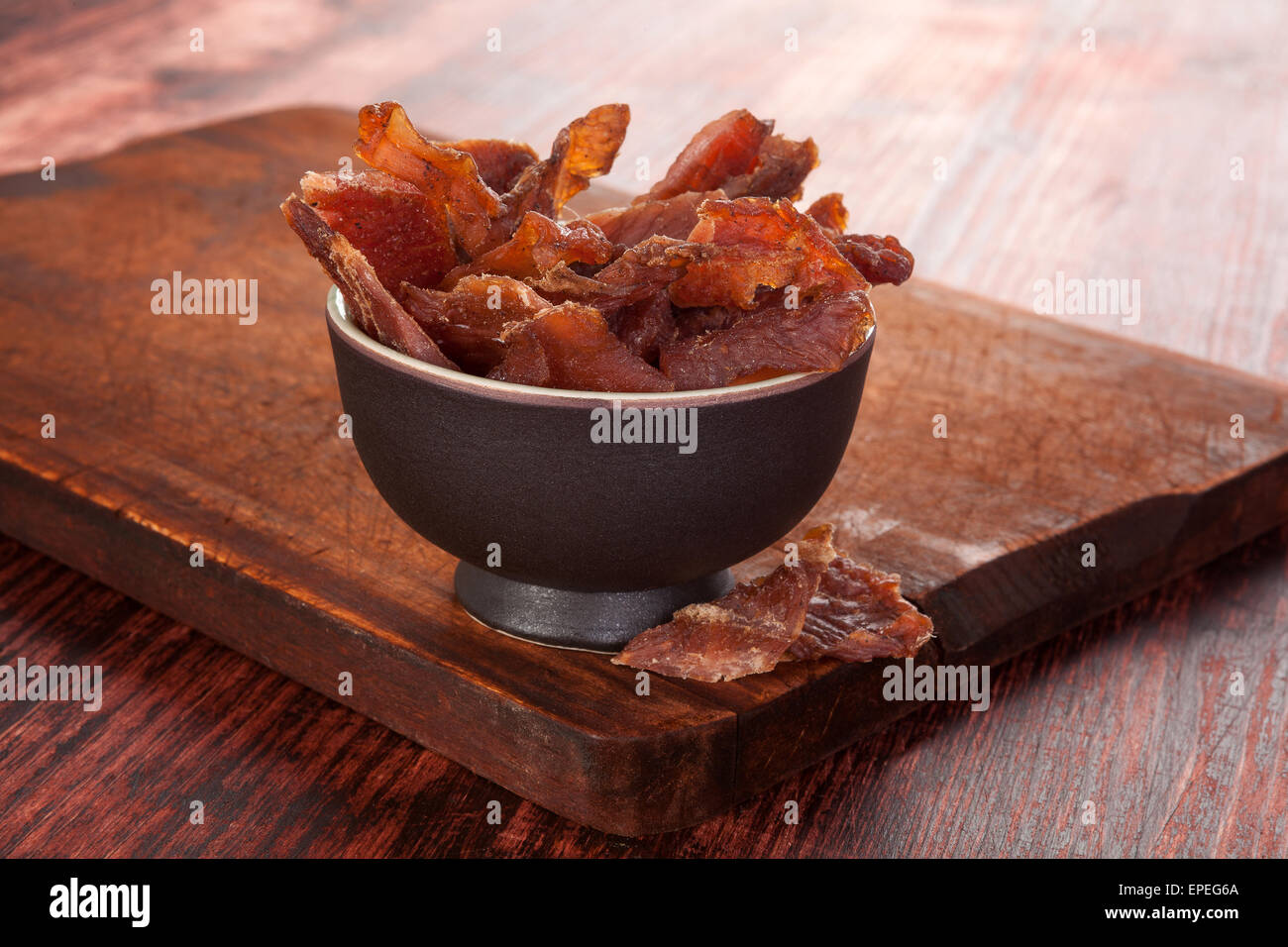 Dörrfleisch. Getrocknete Fleisch Dörrfleisch auf Schneidbrett aus Holz auf Holz Hintergrund. Trockenfleisch, rustikalen Landhausstil. Leckeres Fleisch Stockfoto