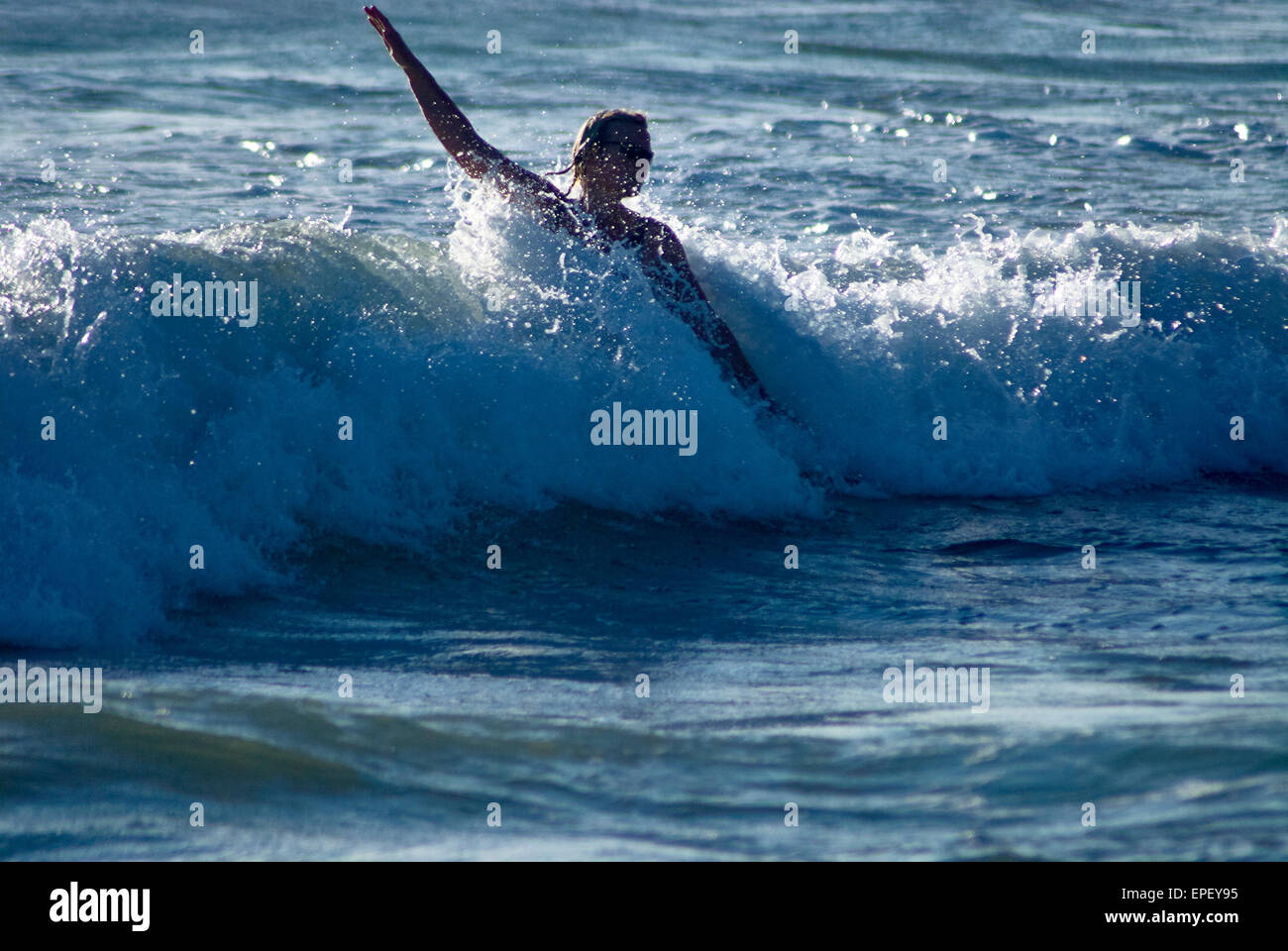 Frauen spielen in den Wellen in Cardigan Bay, Wales, UK Stockfoto