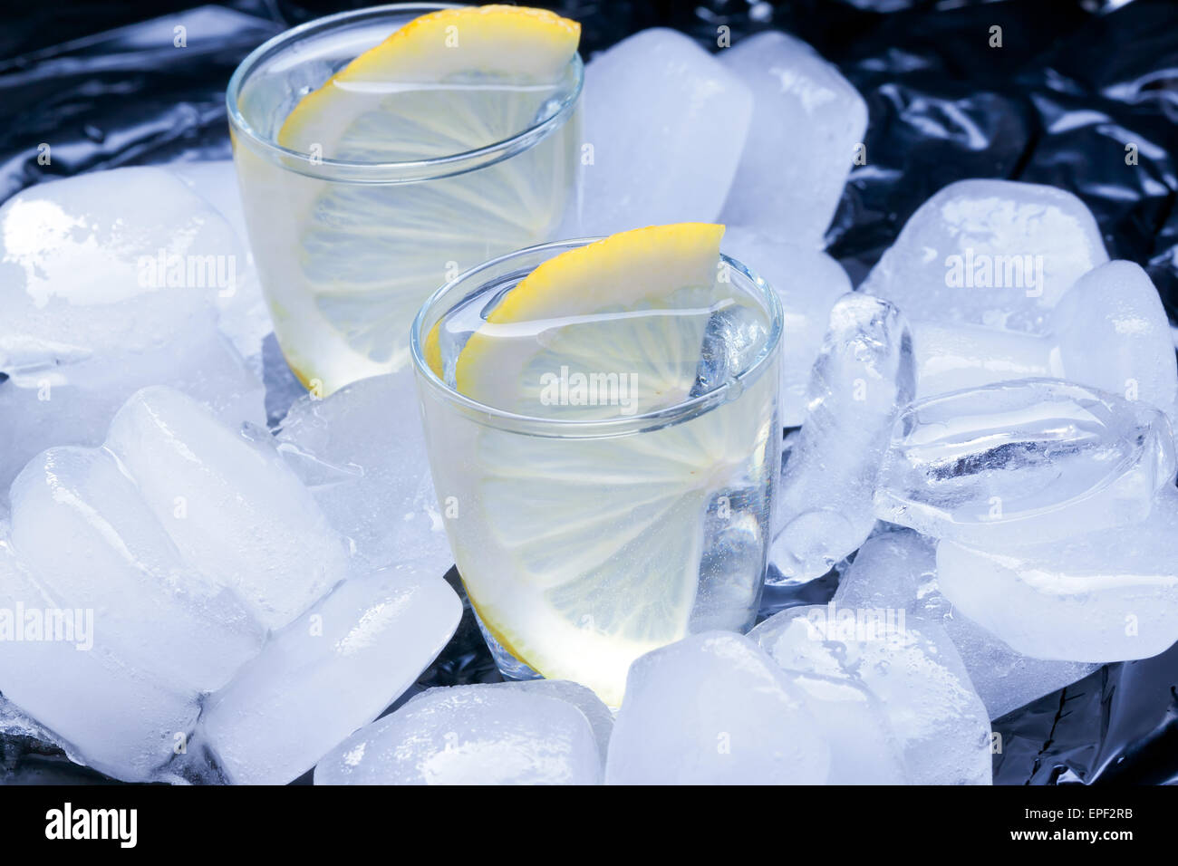 Russischer Vodka mit Zitrone gegossen in einem Glas aus Eis Stockfoto