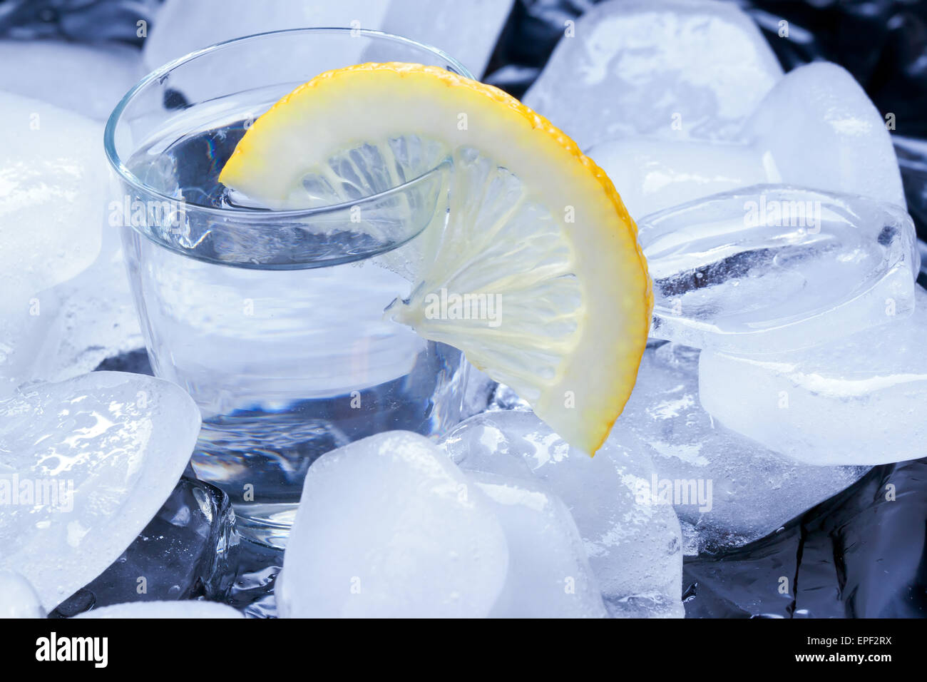 Russischer Vodka mit Zitrone gegossen in einem Glas aus Eis Stockfoto