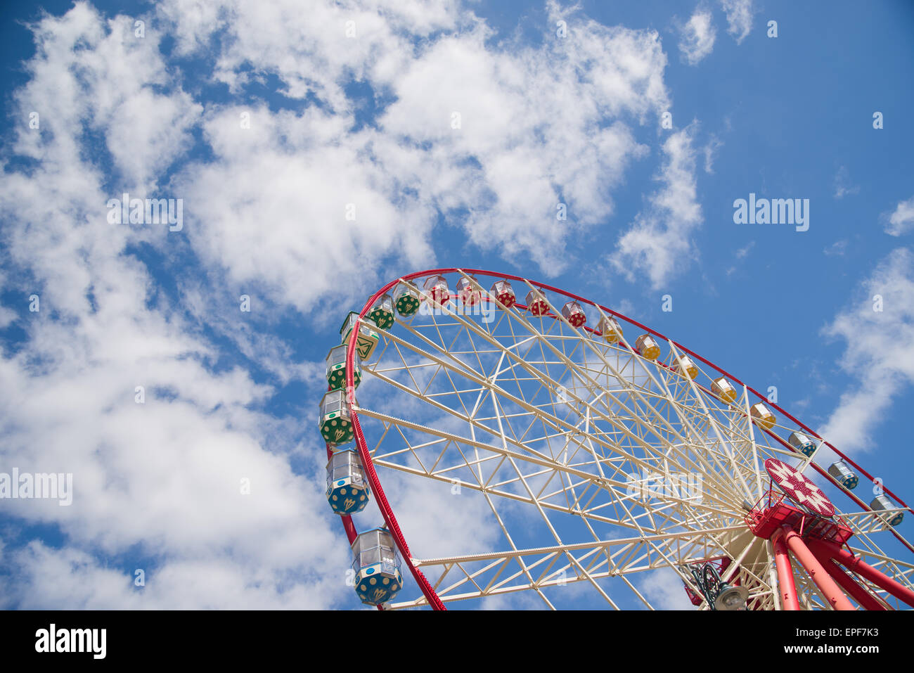 Atraktsion Ferris Wheel vor blauem Himmel mit Wolken Stockfoto