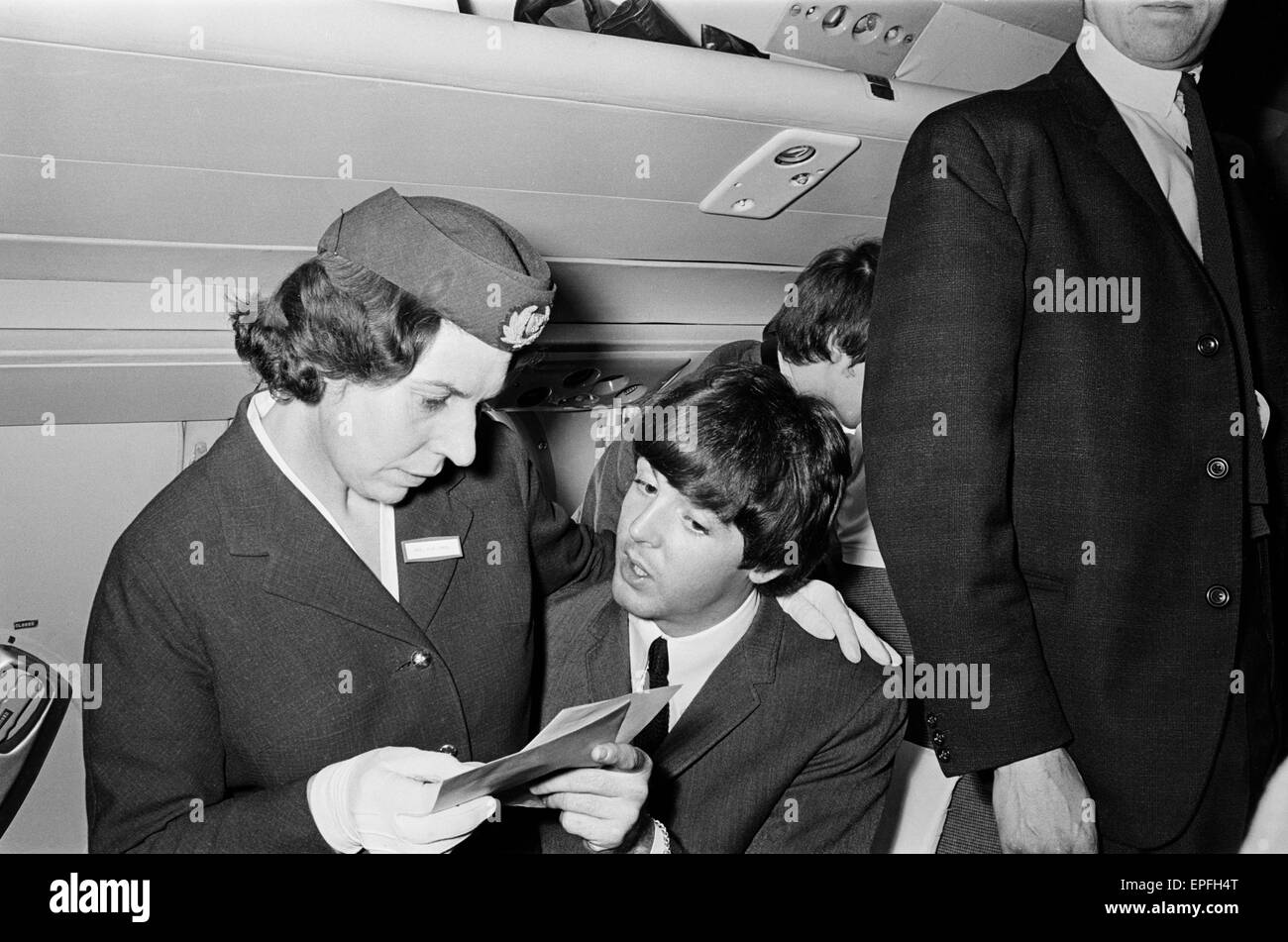 Die Beatles in Liverpool für die Premiere von a Hard Day Night. Paul McCartney hier abgebildet, im Gespräch mit einer Flugbegleiterin auf dem Weg nach Liverpool für die Premiere. 10. Juli 1964. Stockfoto