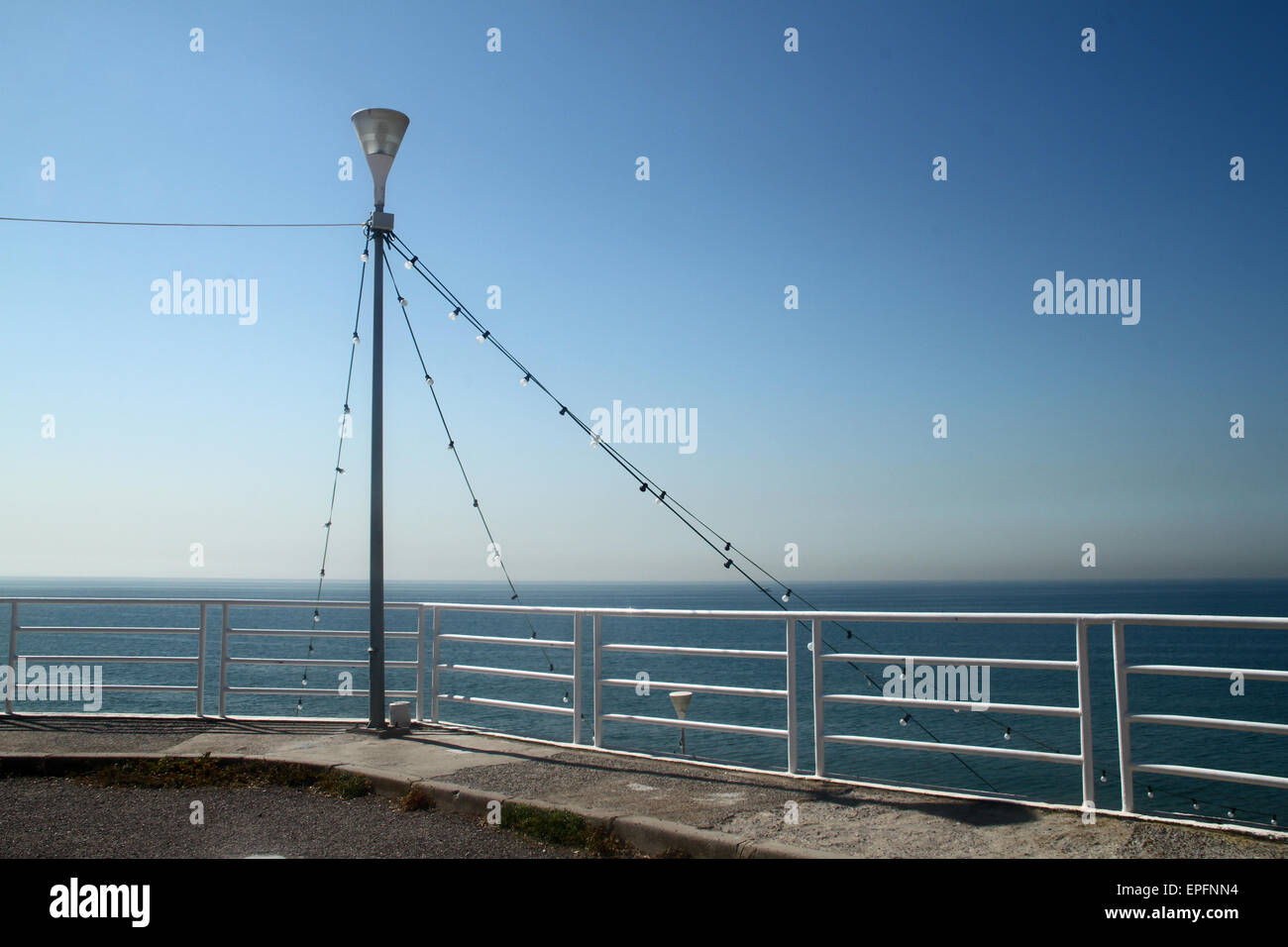 Blauer Himmel und Meer mit Laterne und Geländer im Badeort in Spanien Stockfoto