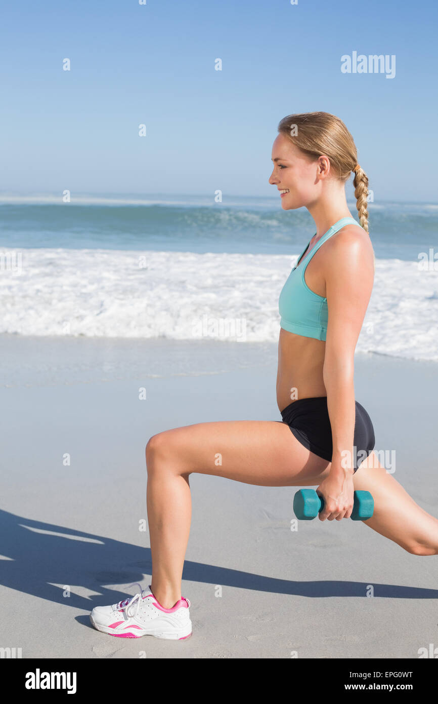 Fit Woman tun gewichteten Ausfallschritte am Strand Stockfoto