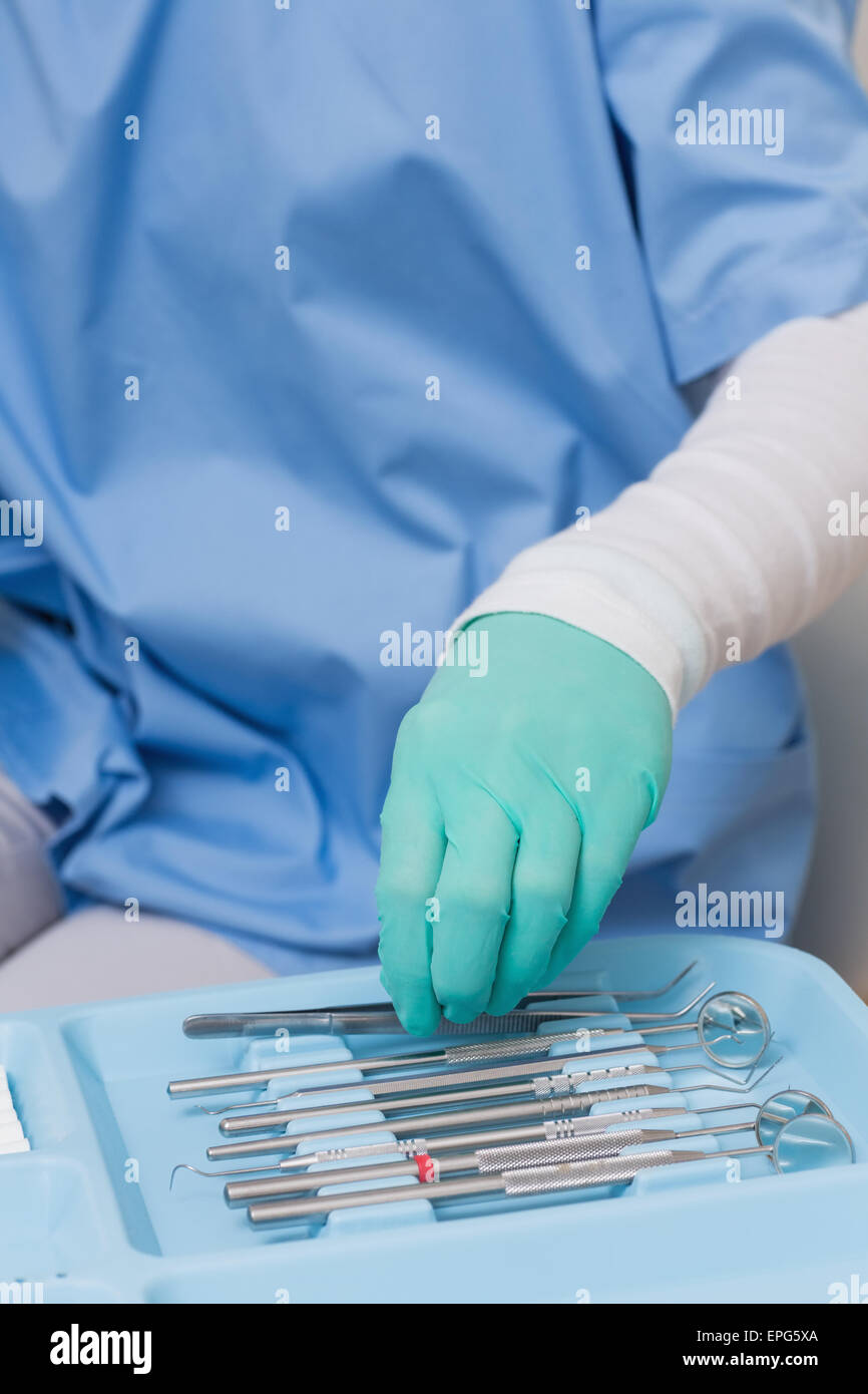 Zahnarzt in blau scheuert Abholung Werkzeuge Stockfoto