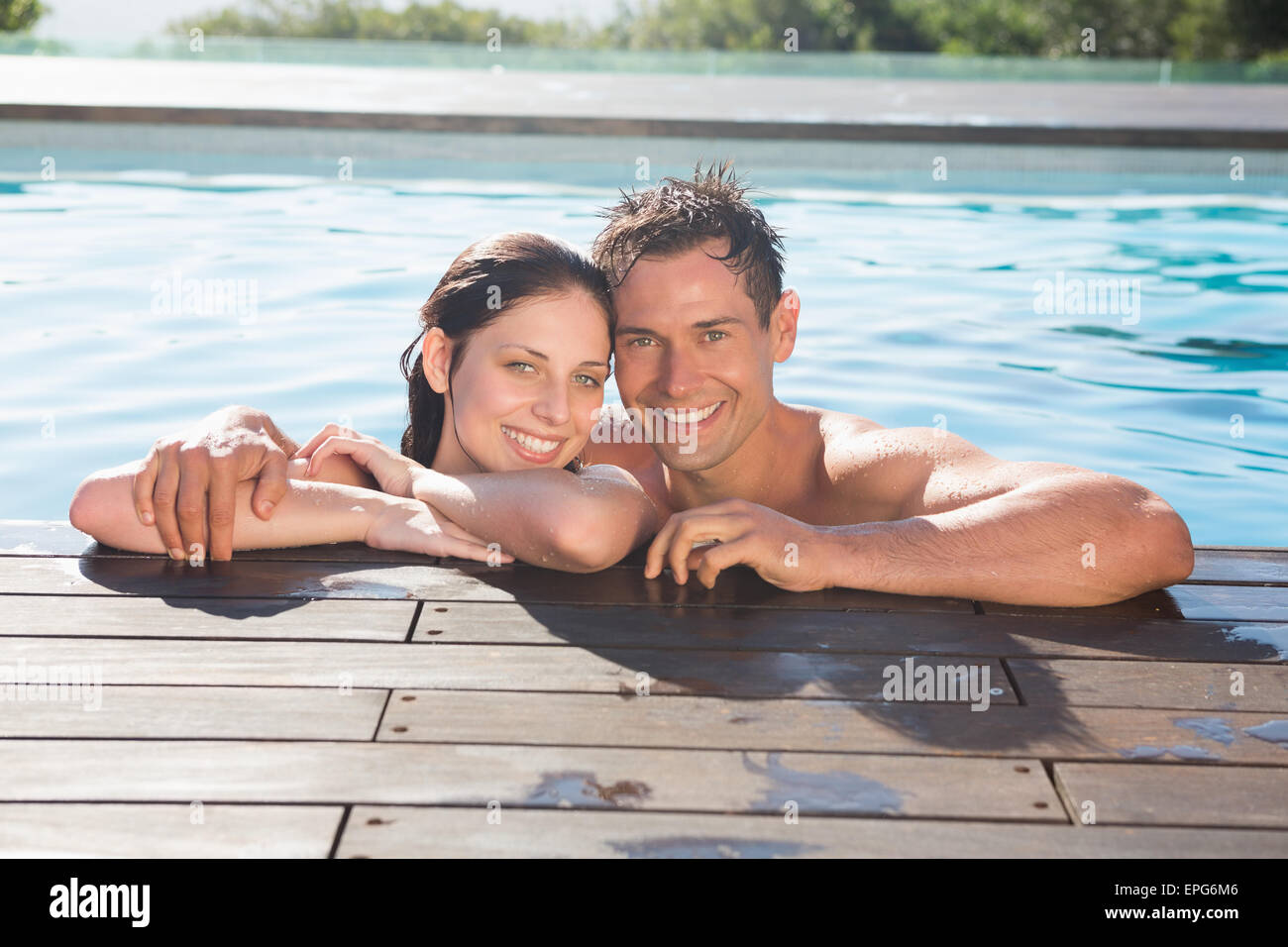 Paar im Schwimmbad an einem sonnigen Tag Stockfoto