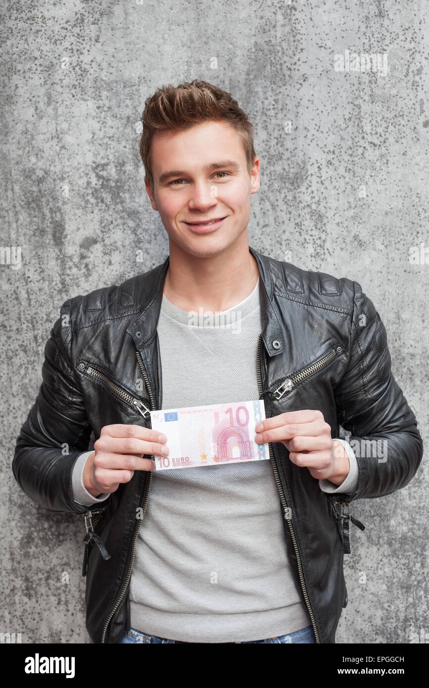 Lässige junge Mann hält zehn-Euro-Schein Stockfoto