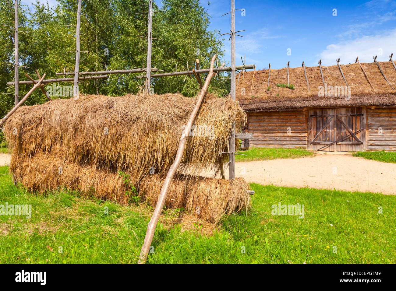 Russische ländliche Holzbaukunst beispielsweise im freien Heu trocknen Bau in der Nähe von alte Scheune mit verschlossenen Tor Stockfoto