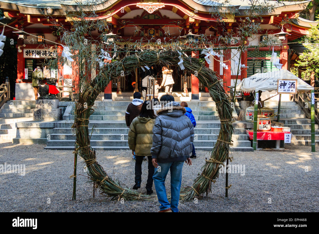 Japan, Nishinomiya, Koshiki-wa-Schrein. Junges Paar betritt den Schrein, indem es durch ein Chi-no-wa geht, einen gedrehten Seilkreis, der für das neue Jahr aufgestellt wurde. Stockfoto