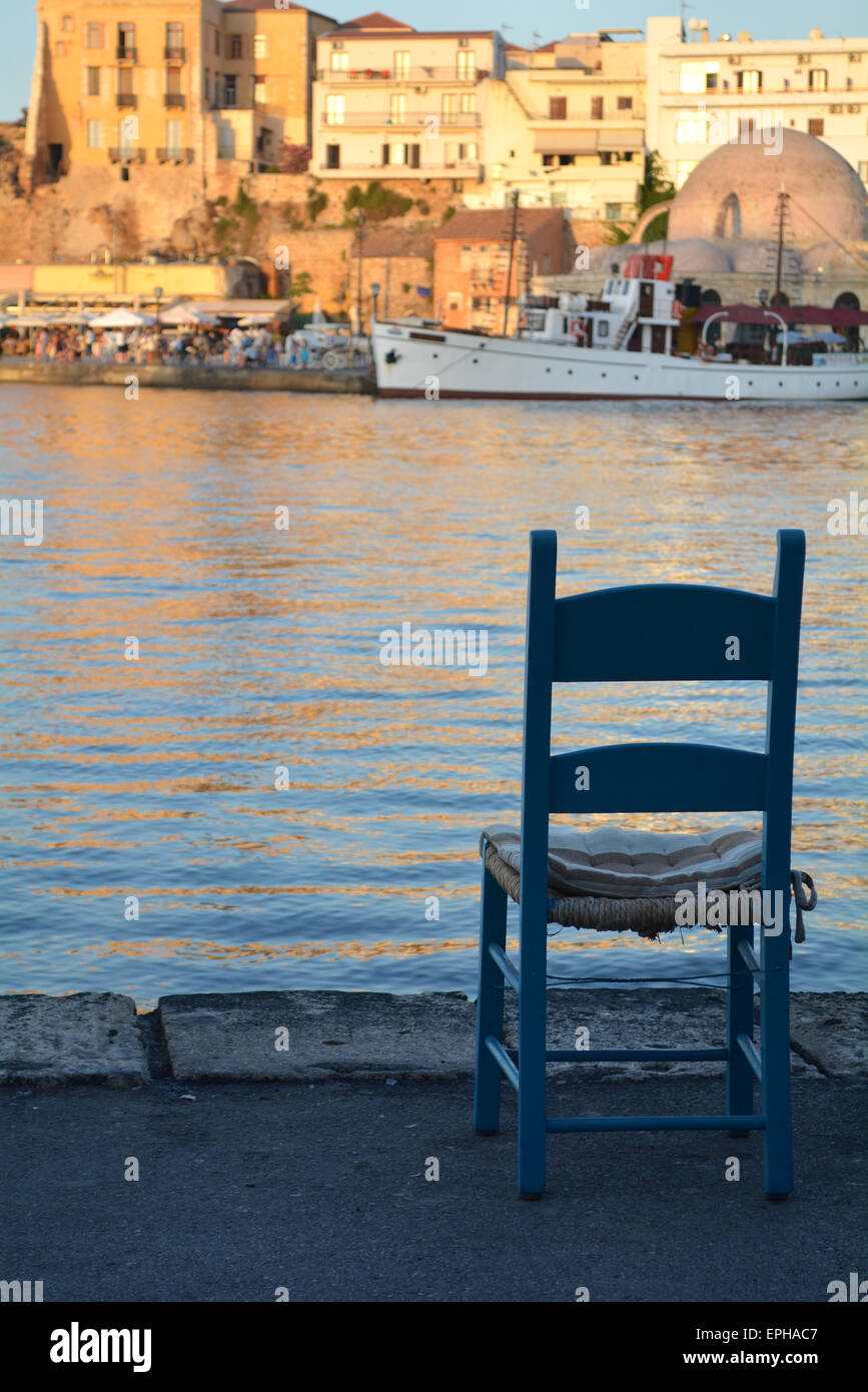 Einzelstuhl mit Blick auf den Hafen bei Sonnenuntergang in Chania, Kreta, Griechenland Stockfoto