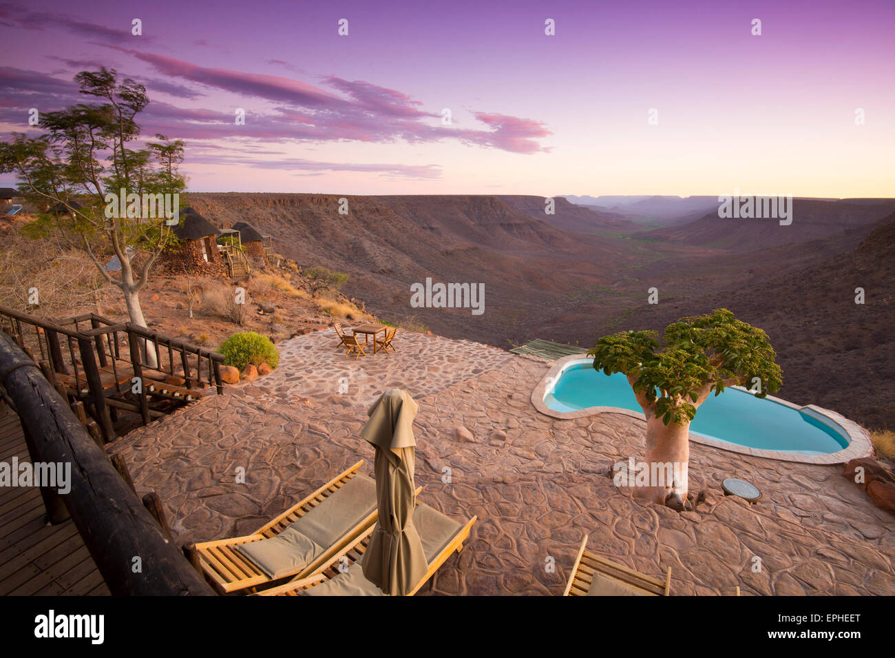 Afrika, Namibia. Grootberg Lodge. Liegestühle und Baum mit Blick auf den Horizont bei Schwimmbad-Szene. Stockfoto