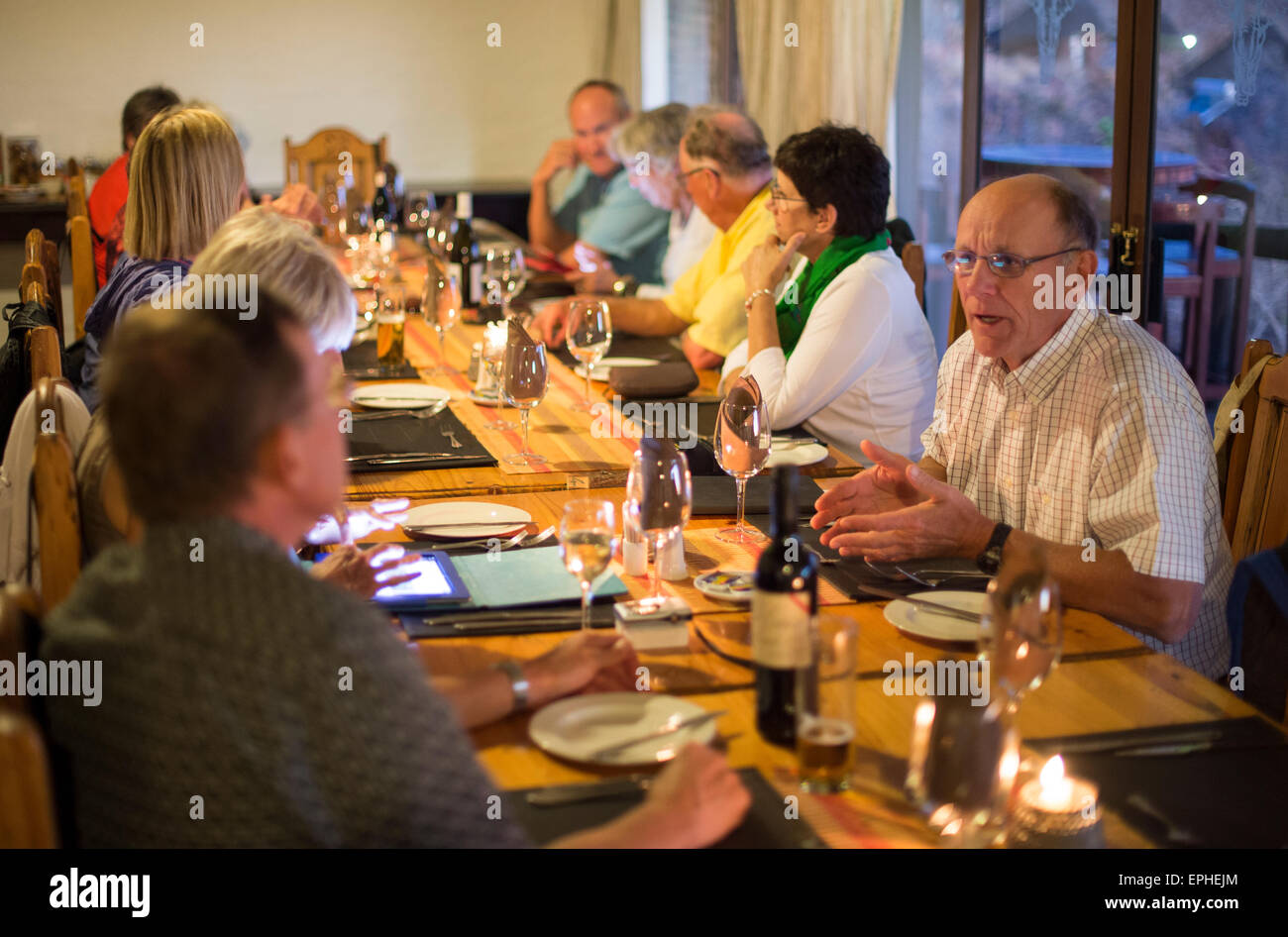 Afrika, Namibia. Grootberg Lodge. Gruppe mit dem Abendessen um großen Tisch. Stockfoto