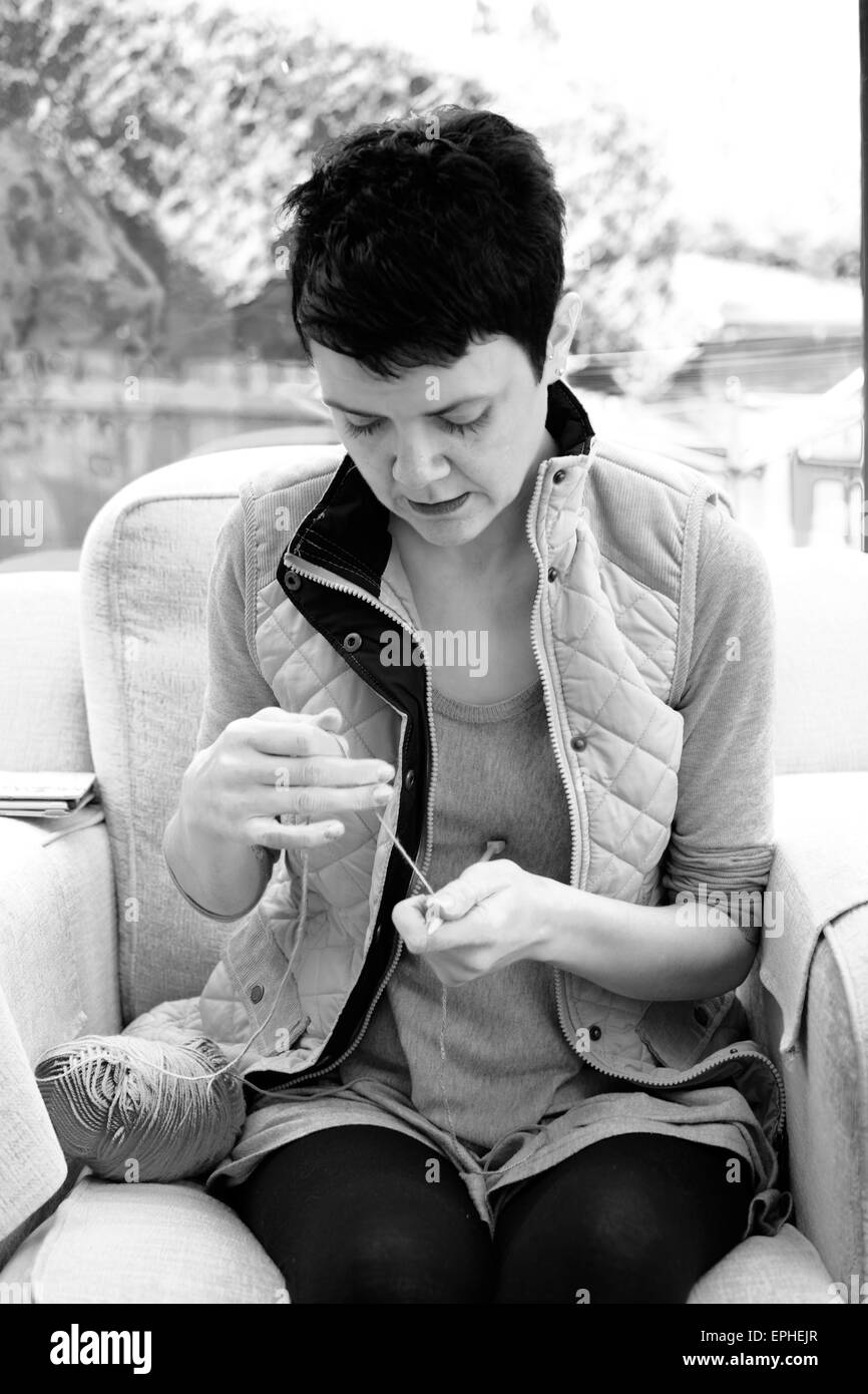 Junge Frau lernen, wie Stricken und die Aufnahme einer neuen Hobby Stockfoto