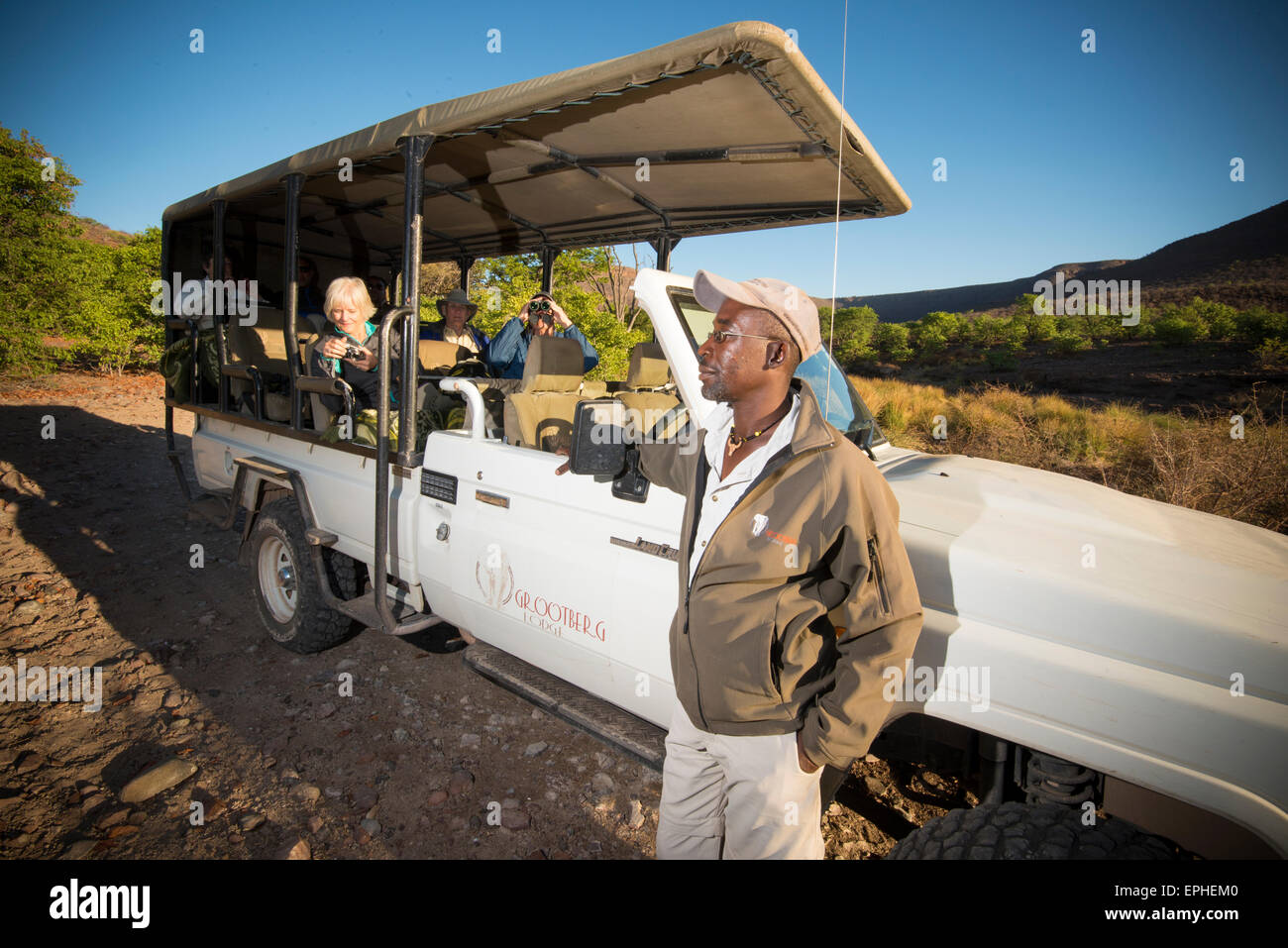 Afrika, Namibia. Verfolgung der Wüste Spitzmaulnashorn Tagesausflug. Hotelführer starrte, Touristen fotografieren. Stockfoto