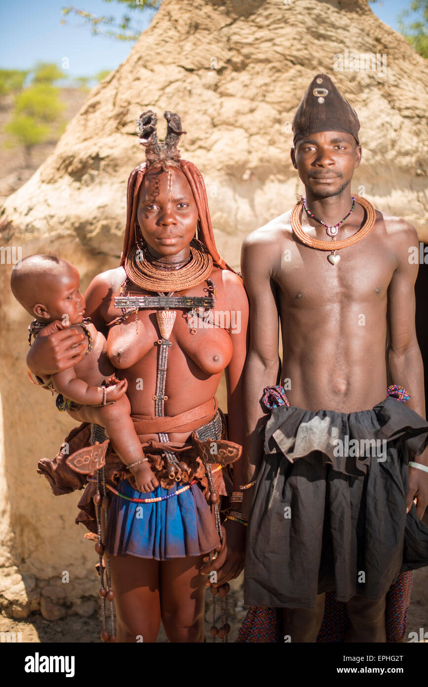 Afrika, Namibia. Himba Dorf. Paar mit Kind posiert. Stockfoto