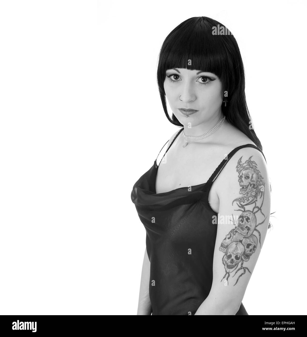 Schöne junge Frau zeigt ihr Schädel Tattoo ist auf dem oberen Arm während im Abendkleid Stockfoto
