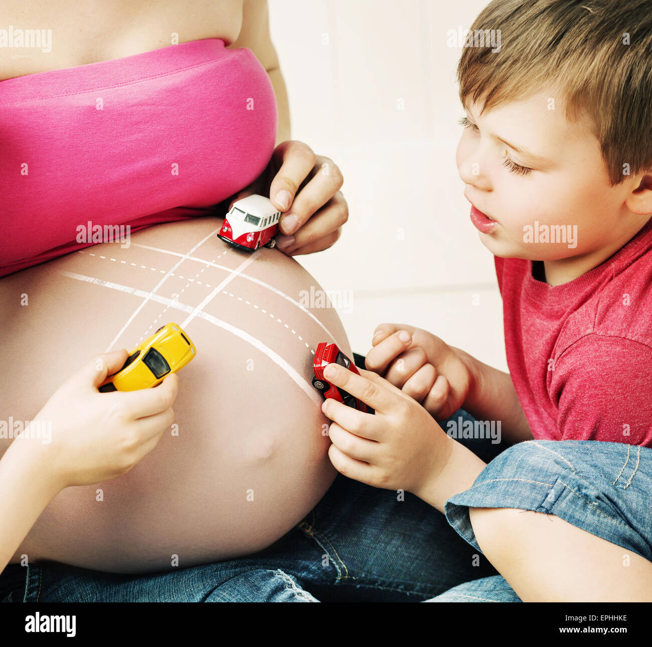Jungs spielen mit einem ungeborenen Bruder Stockfoto
