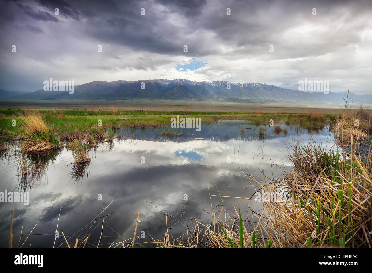 See in der Nähe der Berge am dramatischen bedecktem Himmel in Kasachstan, Zentralasien Stockfoto