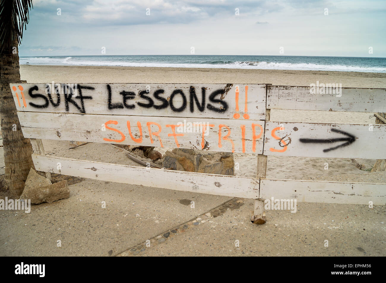 Surf Unterricht Zeichen über einen hölzernen Zaun mit dem Ozean Ont Hintergrund gemalt Stockfoto