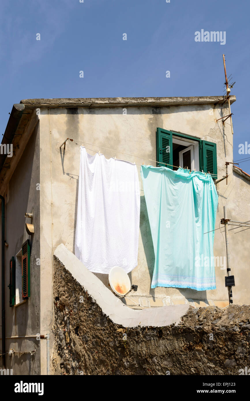 Blick auf die Altstadt Fassade mit scharfen Kontrast zwischen traditionellen hängende Wäsche in der Sonne und Satellitenschüssel, Portovenere, Italien Stockfoto