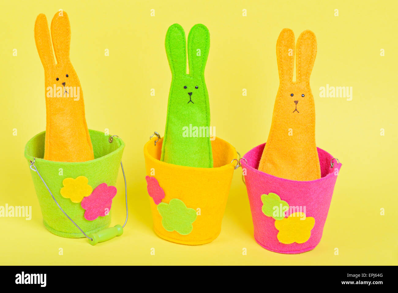 Drei Ostern Bunnys in Eimern auf gelb Stockfoto