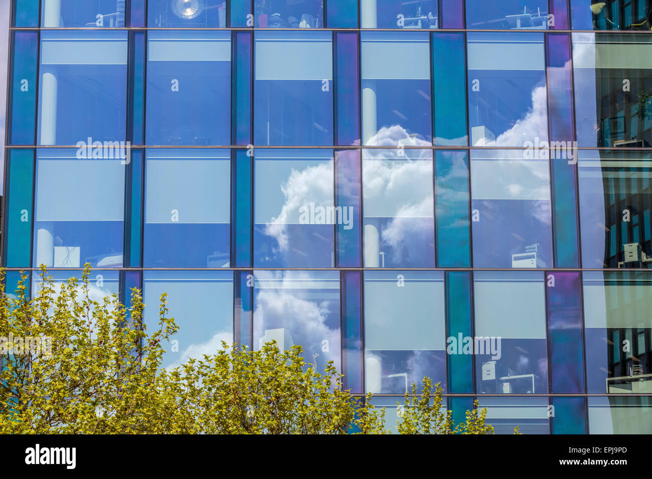 Ein Bild von einer Reflexion eines Cumulus Cloud in einer Glasfront Bürogebäude in London England Großbritannien Stockfoto