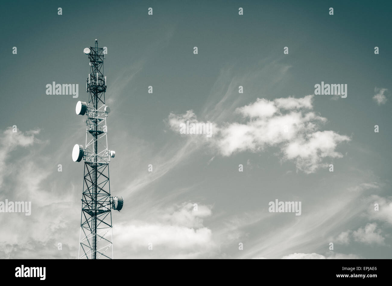 Aerial Mast mit vielen Antennen und Gerichte mit Wolken, die aussehen wie Wellen Stockfoto