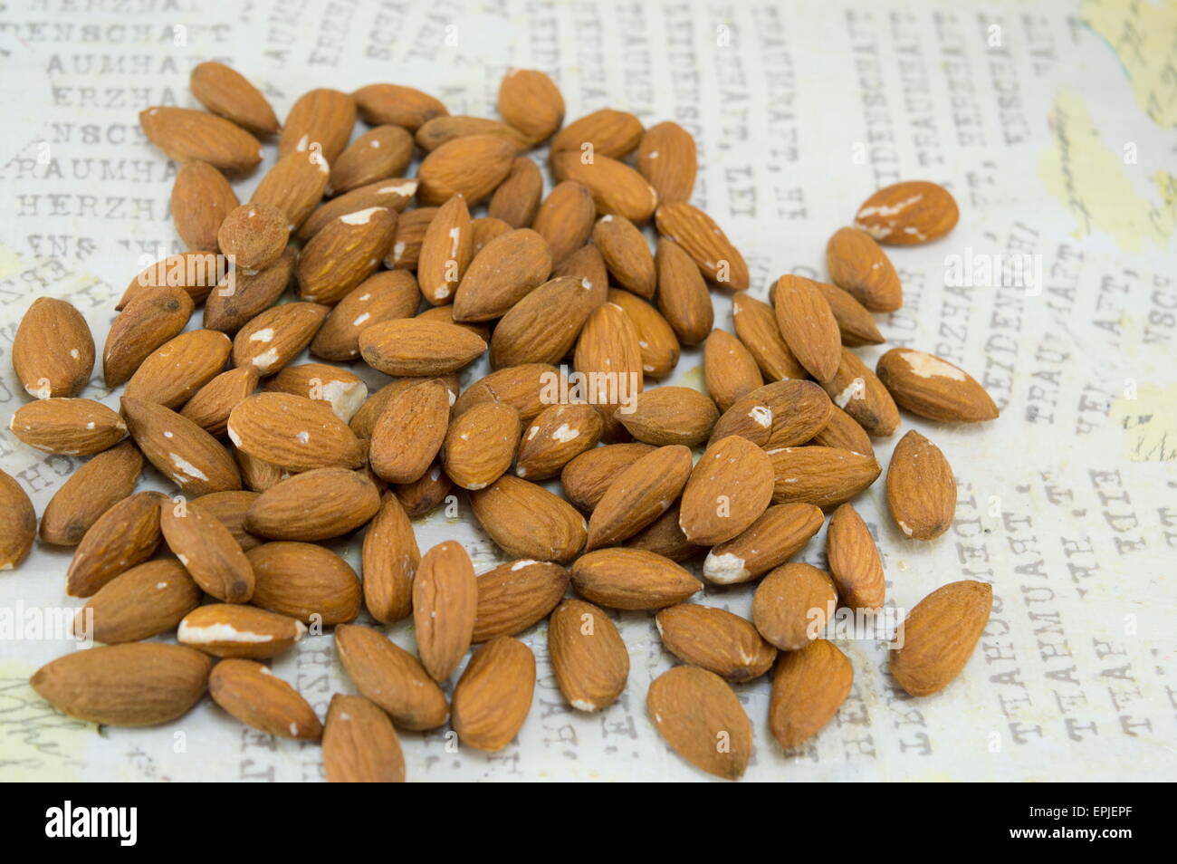 Decoupage-Tisch gedeckt mit einem Bündel von rohen Mandeln Stockfoto