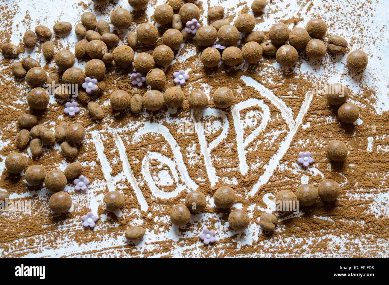 Schokokugeln auf einem Tisch mit dem Wort Happy geschrieben in der Schokolade Stockfoto